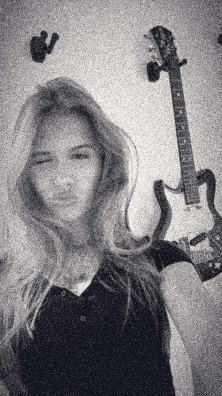 Zelda winking in front of a guitar, black and white